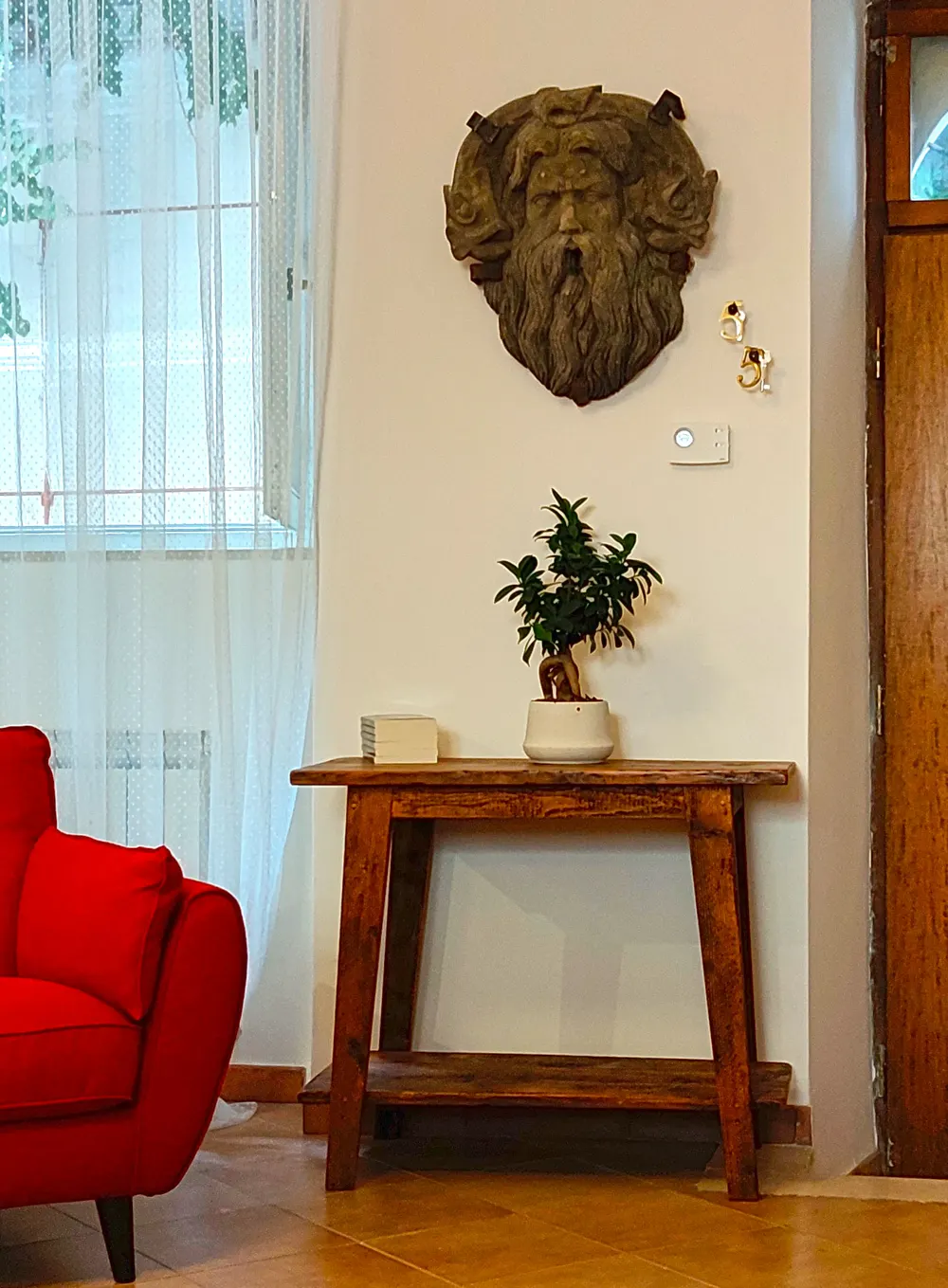L'ingresso di Civico 5, con la maschera scolpita e la porta ad arco